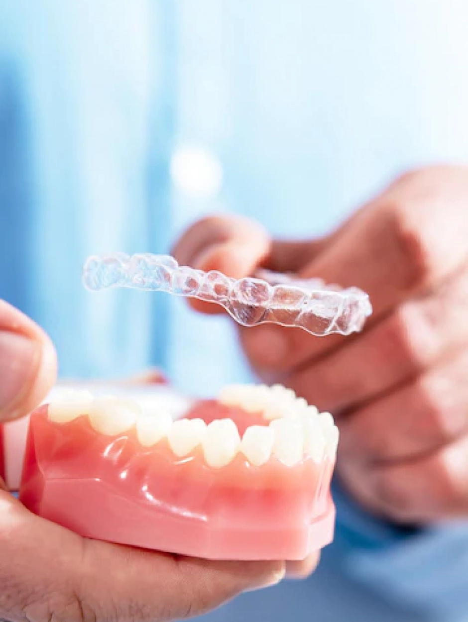 closeup-doctor-puts-transparent-aligners-teeth-artificial-jaw_114354-2523